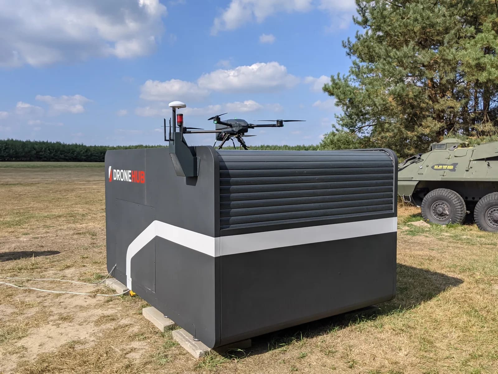 A Dronehub drone-in-a-box docking station fielded in the open, with an autonomous quadcopter on the launch deck.